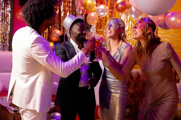 ナイトクラブのパーティーでシャンパンをグラスで乾杯する4人の幸せで多様な友人 楽しさ 飲み物 包括性とパーティーのコンセプト — ストック写真