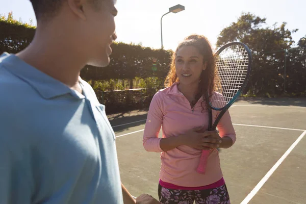 Улыбающаяся Двуличная Пара Играющая Теннис Разговаривающая Сети Солнечном Открытом Теннисном — стоковое фото