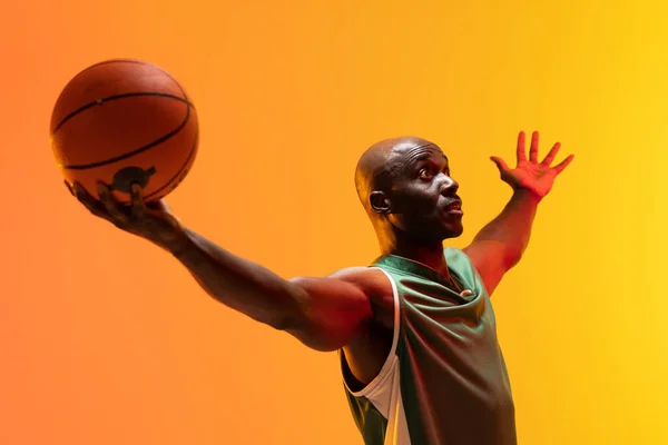 Obrázek Afrického Amerického Basketbalisty Basketbalem Neonově Oranžovém Pozadí Sportovní Soutěžní — Stock fotografie