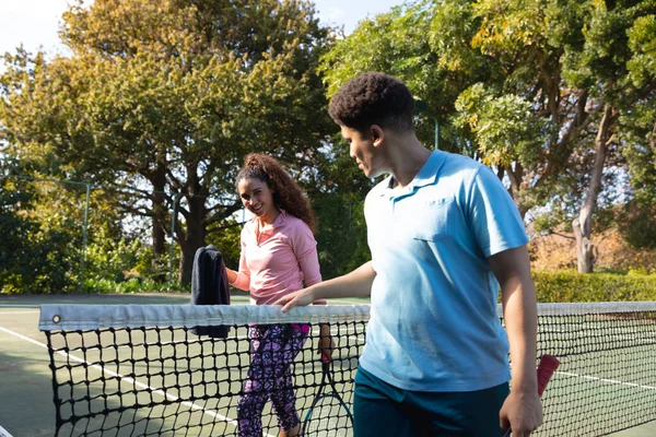 Usmívající Biracial Pár Hrát Tenis Mluvit Přes Síť Slunném Venkovním — Stock fotografie