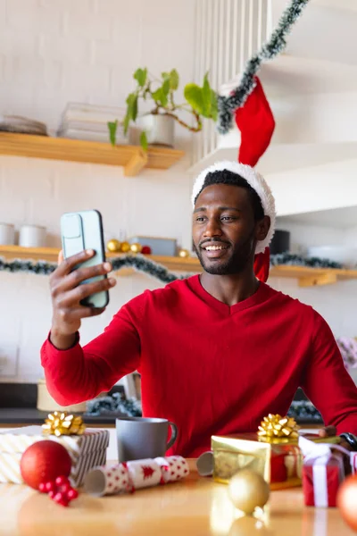 Щасливий Афроамериканець Одягнений Санта Капелюх Користується Смартфоном Відеодзвінка Проводячи Якісний — стокове фото