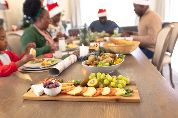 African american family spending time together at the table having a christmas meal. Christmas, family time and celebration concept.