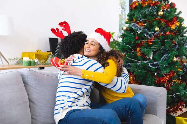 아프리카 미국인 거실에 소파에 포옹하고 있습니다 크리스마스에 시간보내기 — 스톡 사진