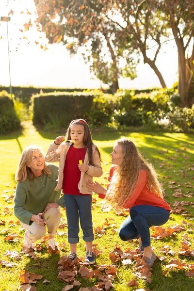 庭に石鹸泡を持つ幸せな3世代の白人女性の垂直画像 家族と一緒に質の高い時間を過ごすコンセプト — ストック写真