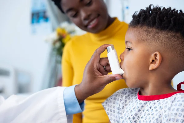 Ręka Afrykańskiego Amerykańskiego Lekarza Podającego Inhalator Chłopcu Uśmiechniętą Matką Usługi — Zdjęcie stockowe