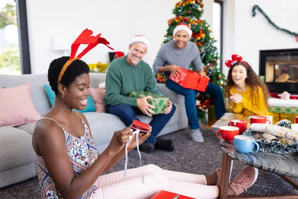 幸せなアフリカ系アメリカ人女性が友人と家でクリスマスを祝う贈り物を開くイメージ クリスマス お祝い 包括性とライフスタイルの概念 — ストック写真