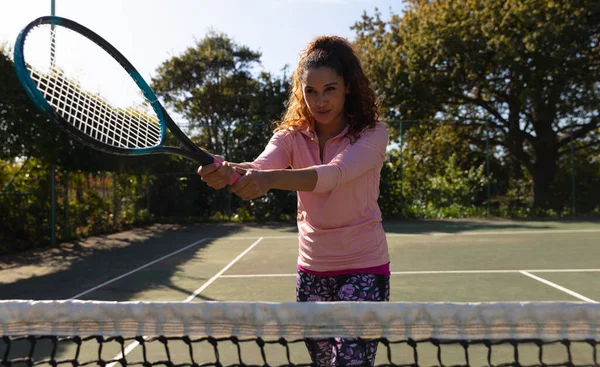 Biracial Γυναίκα Παίζει Τένις Ταλάντευση Ρακέτα Πάνω Από Δίχτυ Στο — Φωτογραφία Αρχείου