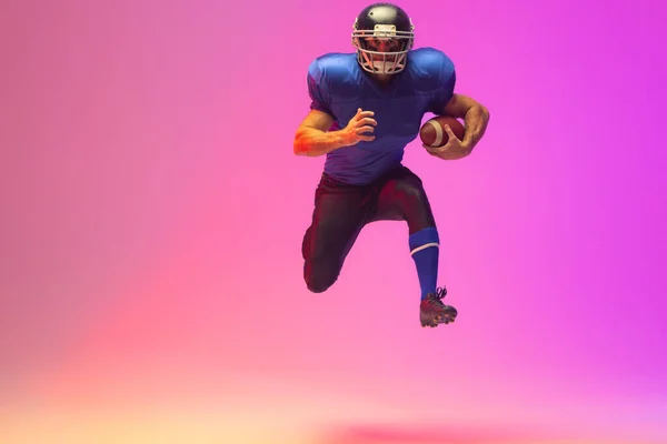 Kaukasischer Männlicher Amerikanischer Fußballspieler Mit Ball Neonpinkfarbener Beleuchtung Sport Bewegung — Stockfoto