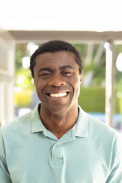 家の外で誰かを歓迎する幸せなアフリカ系アメリカ人男性の垂直写真 家で一緒に過ごす — ストック写真