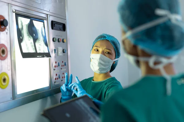 Twee Verschillende Vrouwelijke Chirurgen Bespreken Röntgenfoto Lightbox Operatiekamer Ziekenhuis Medische — Stockfoto