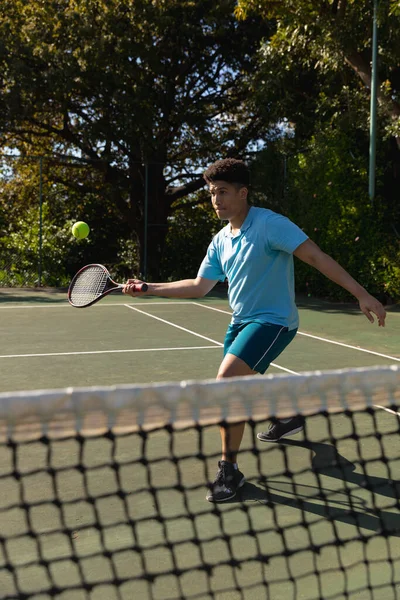 Biracial Hombre Jugando Tenis Regresando Pelota Sobre Red Soleada Cancha — Foto de Stock