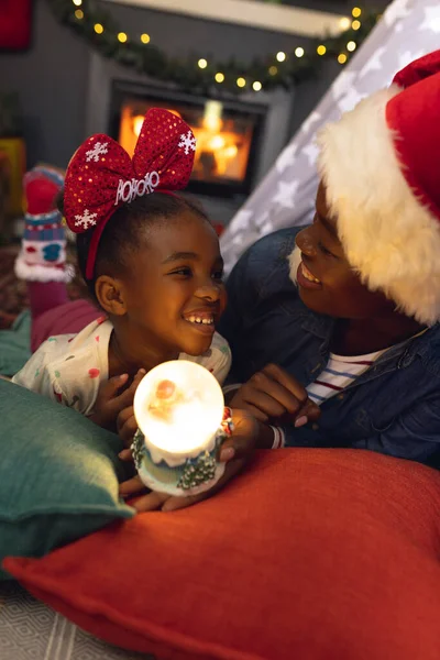 アフリカ系アメリカ人の母親と娘の垂直写真がおしっこや遊びに横たわっています クリスマス 家族の時間とお祝いの概念 — ストック写真