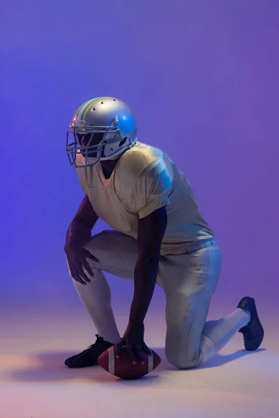 Amerykański Amerykański Futbolista Trzymający Piłkę Neonowym Niebieskim Oświetleniem Sport Ruch — Zdjęcie stockowe