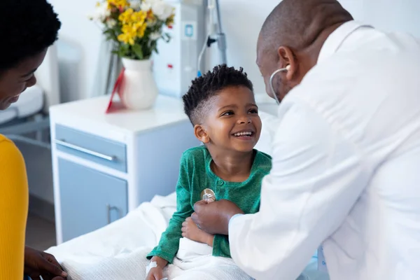 African American Male Doctor Using Stethoscope Smiling Boy Patient Hospital — Stock Photo, Image