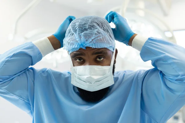Αφροαμερικανός Χειρουργός Ρόμπα Και Καπέλο Που Δένει Μάσκα Στο Χειρουργείο — Φωτογραφία Αρχείου
