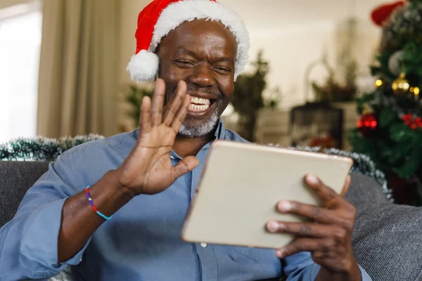 Mutlu Kıdemli Afro Amerikan Adam Noel Baba Şapkalı Tablet Kullanıyor — Stok fotoğraf
