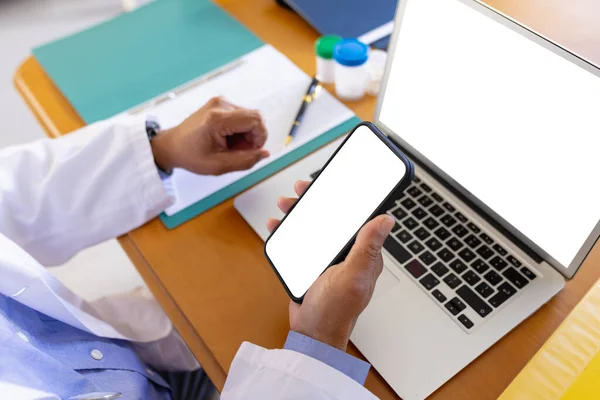 スマートフォンやノートパソコンを使ったデスクの男性医師画面上のスペースをコピーします 医療サービス 遠隔医療 包括的な概念 — ストック写真