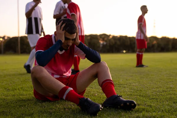 Kafkasyalı Üzgün Sporcu Karada Oturuyor Arka Planda Oyuncuları Var Rekabet — Stok fotoğraf