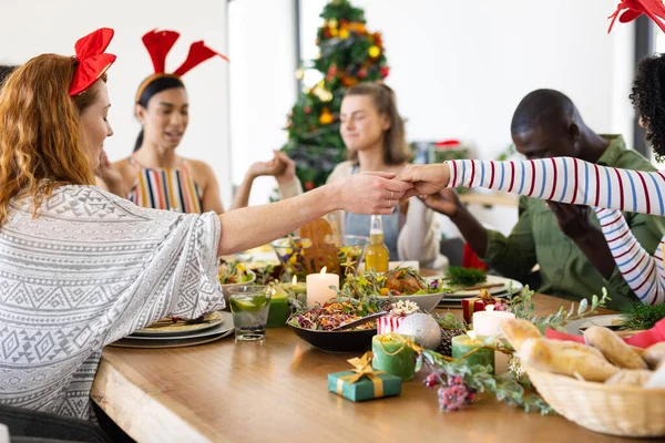 Felices Amigos Diversos Sentados Mesa Rezando Antes Cena Navidad Navidad —  Fotos de Stock