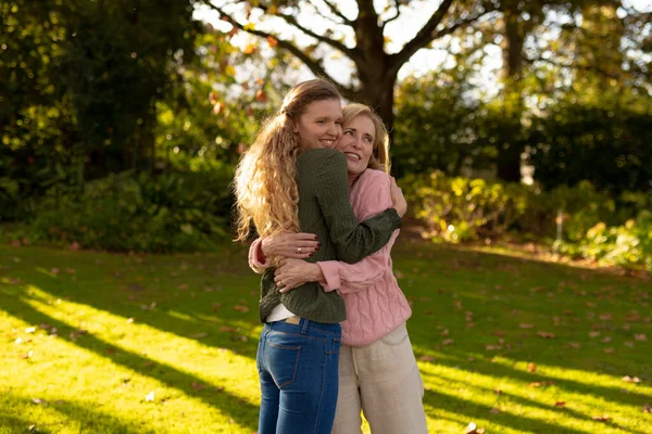 秋天的花园里 快乐的高加索母亲和成年女儿在镜头前摆姿势 家庭与共同度过美好时光的概念 — 图库照片
