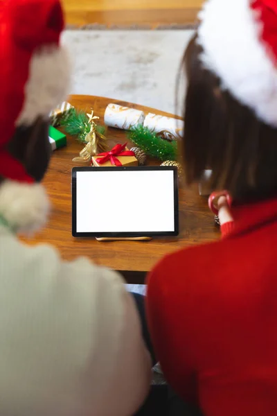 Szczęśliwa Zróżnicowana Para Nosząca Czapki Świętego Mikołaja Korzystająca Tabletu Przestrzenią — Zdjęcie stockowe