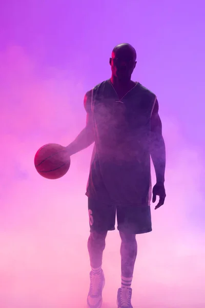 バスケットボールをしたアフリカ系アメリカ人バスケットボール選手のイメージと紫の背景に煙 スポーツ 競技の概念 — ストック写真