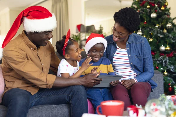 坐在沙发上使用平板电脑的非裔美国人家庭 圣诞节 家庭时间和利用技术庆祝的概念 — 图库照片