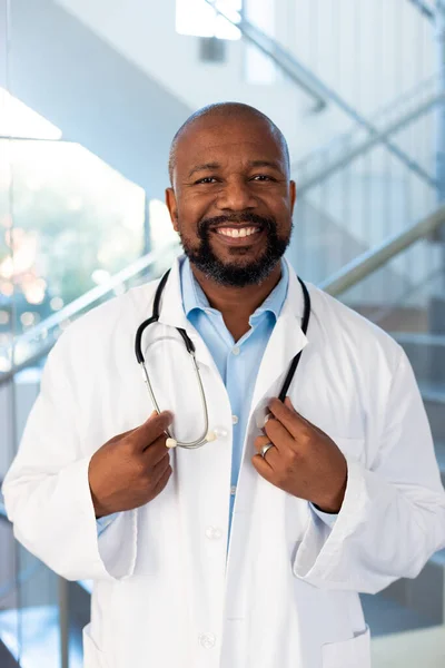 Verticaal Portret Van Lachende Afro Amerikaanse Mannelijke Dokter Ziekenhuisgang Ziekenhuis — Stockfoto