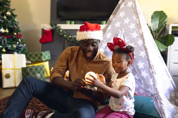 幸せなアフリカ系アメリカ人の父と娘がおしっこや遊びに座っています クリスマス 家族の時間とお祝いの概念 — ストック写真