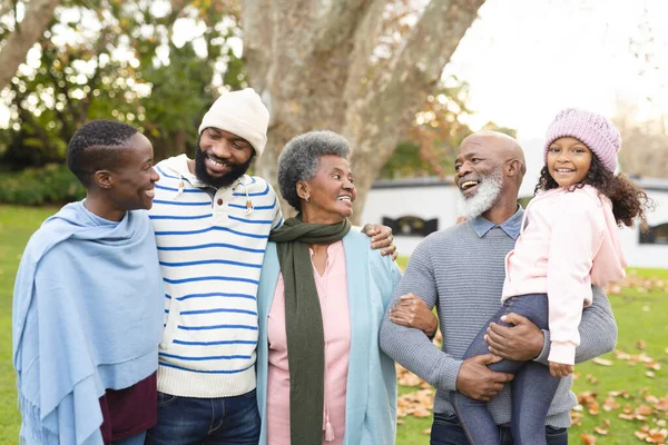 Image of happy multi generation african american family having fun outdoors in autumn. Extended family, spending quality time together concept.