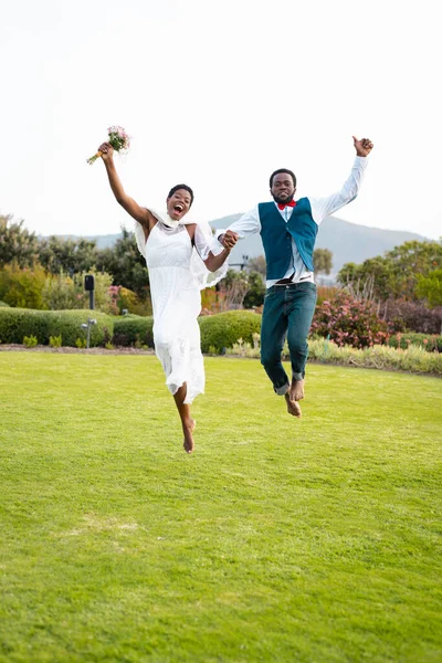 Mutlu Afro Amerikan Çiftlerin Portresi Düğün Sırasında Ele Tutuşup Zıplıyorlar — Stok fotoğraf