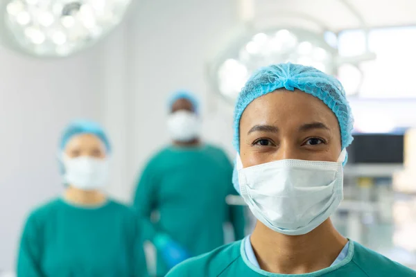 Portrét Usmívající Biraciální Chirurgky Masce Čepici Operačním Sále Kolegy Nemocniční — Stock fotografie