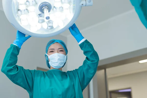 Sorrindo Asiática Cirurgião Feminino Ajustando Luzes Sala Operações Para Operação — Fotografia de Stock