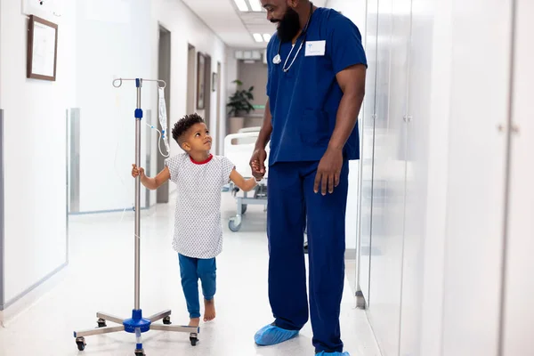 Щасливий Африканський Лікар Чоловік Який Тримає Руку Пацієнта Хлопчика Краплиною — стокове фото