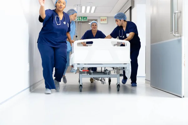 病院の廊下の下のベッドで患者を押す医療従事者の多様なグループ コピースペースと 医療サービス — ストック写真