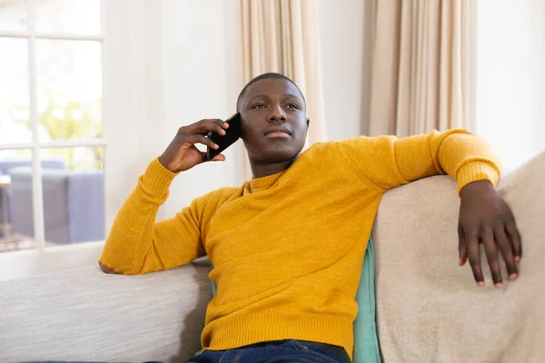 Homme Afro Américain Réfléchi Assis Sur Canapé Maison Utilisant Smartphone — Photo