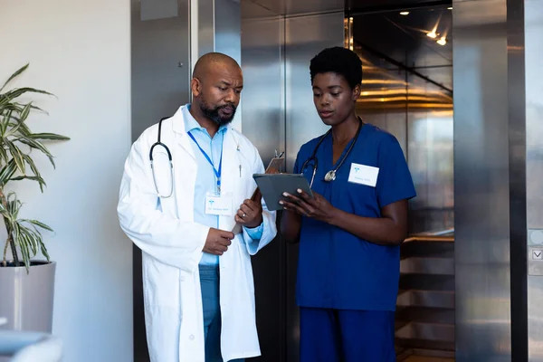 Médico Afroamericano Femenino Masculino Mirando Tableta Por Ascensor Hospital Servicios — Foto de Stock