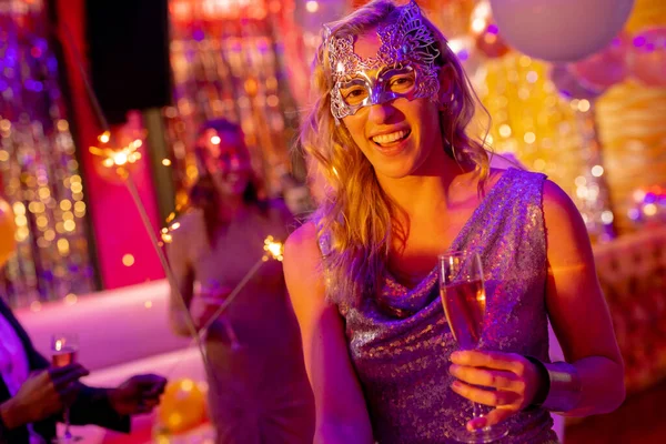 ナイトクラブのパーティーでシャンパンのガラスを保持マスクに笑みを浮かべて白人女性の肖像画 楽しさ お祝い パーティーのコンセプト — ストック写真