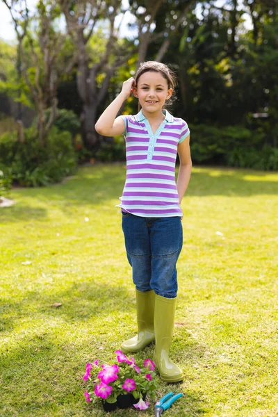 年轻的高加索女孩穿着条纹T恤站在花园里的垂直肖像 在概念之外单独度过时间 — 图库照片