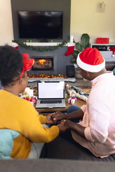 アフリカ系アメリカ人の夫婦の顔の時間があり コピースペースとラップトップを使用しての垂直画像 テクノロジーを使ったクリスマス 家族の時間 お祝いのコンセプト — ストック写真