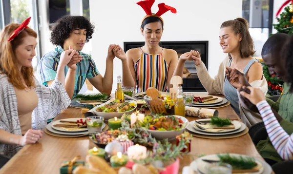 Diversos Amigos Felizes Sentados Mesa Rezando Antes Jantar Natal Natal — Fotografia de Stock