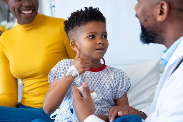 非裔美国男性医生向住院的男病人和母亲解释吸入器 医疗和保健服务 — 图库照片