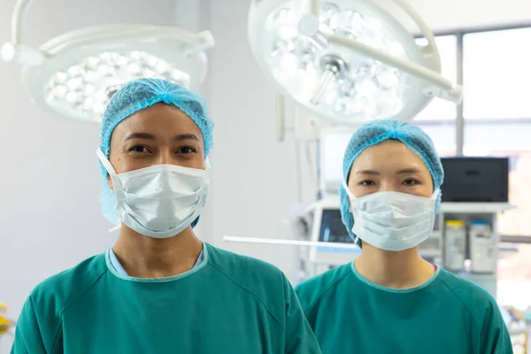 Retrato Duas Cirurgiãs Diversas Bonés Máscaras Sorrindo Sala Operações Serviços — Fotografia de Stock