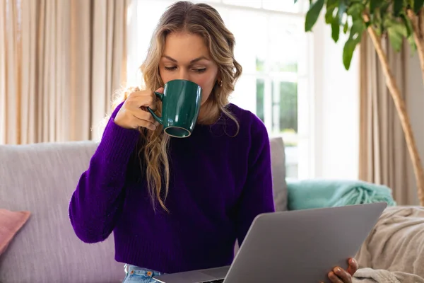 Donna Cucasian Utilizzando Computer Portatile Bere Caffè Seduto Sul Divano — Foto Stock