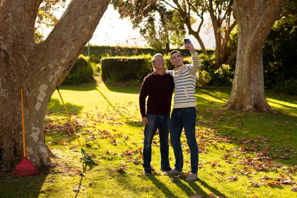 一个快乐的高加索父亲和成年儿子在花园里自拍的画面 家庭与共同度过美好时光的概念 — 图库照片