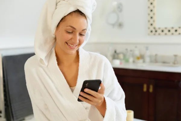 Szczęśliwa Biała Kobieta Szlafroku Używająca Smartfona Łazience Spędzanie Czasu Samotnie — Zdjęcie stockowe