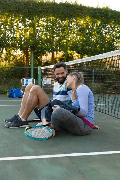 一对快乐的高加索夫妇在室外网球场上 在打网球后通过网来恢复 健康爱好 健身和闲暇时间概念 — 图库照片