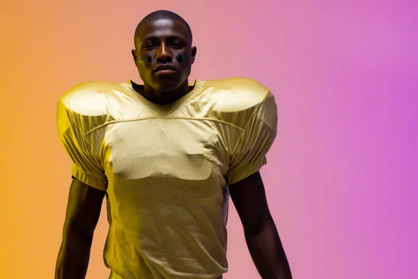 非裔美国男性足球运动员 有霓虹灯黄色和紫色灯 培训和积极生活方式概念 — 图库照片