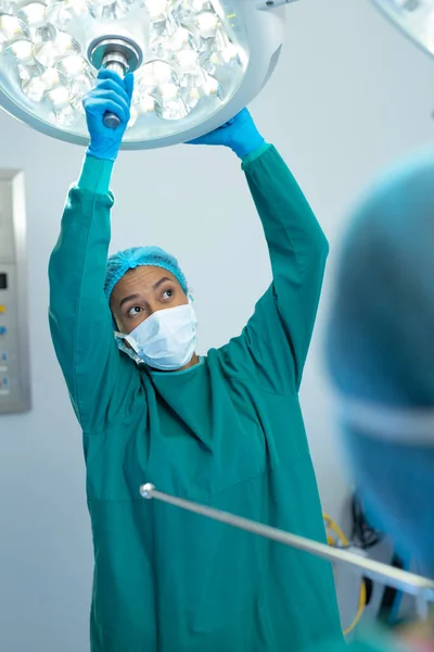 Vertikalt Sett Kvinnelige Kirurger Som Justerer Lys Operasjonsstuen Operasjon Kopieringsrom – stockfoto