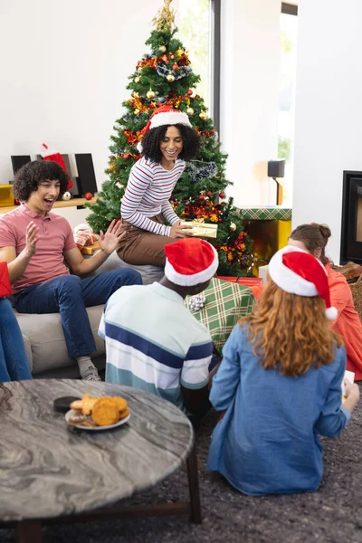 クリスマスにサンタの帽子や贈り物と幸せな多様な友人 クリスマス お祝い 包容力とライフスタイルの概念 — ストック写真